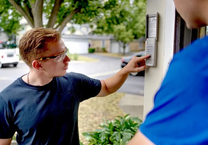 Person using a garage door keypad mounted beside the garage opening