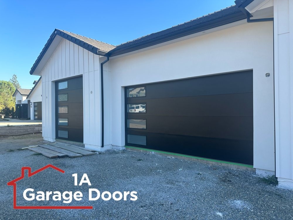 Installed dark residential sectional garage door with vertical windows